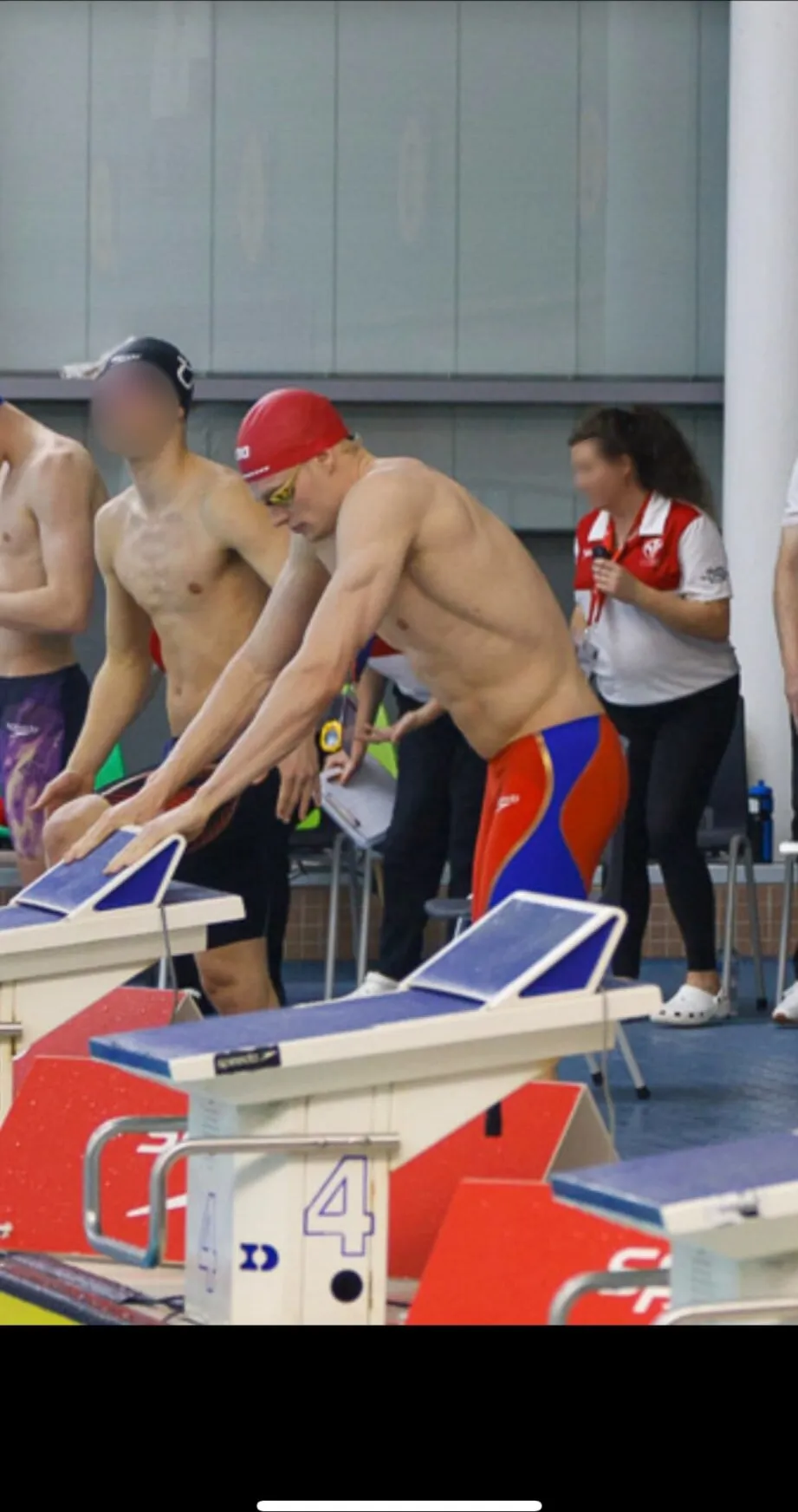 Ryan behind the starting blocks in a red cap, leaning forward ready to race.