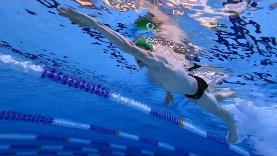 Underwater view of Ryan swimming freestyle, body flat and arm extended forward at the catch.